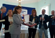 Elsa González hace entrega a Dolores Gallardo de una placa en conmemoración del centenario de la Asociación de la Prensa de Cantabria